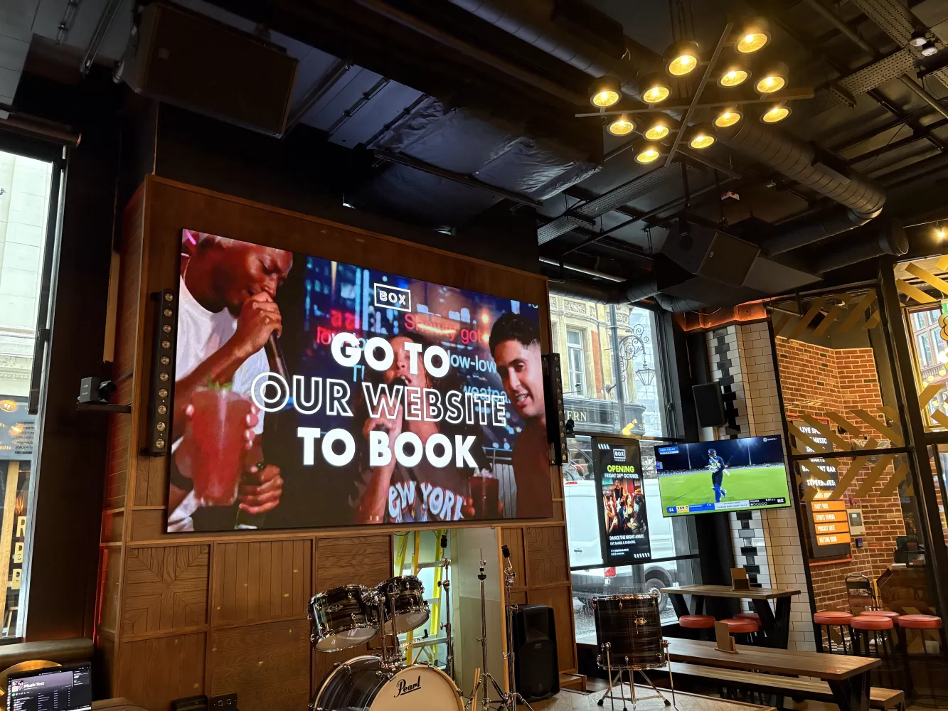 Sports bar interior with multiple screens and ceiling speakers